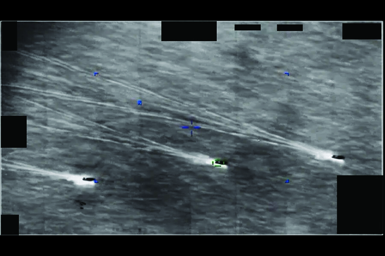 Image showing objects in formation with trails, a crosshair, and redacted portions.
