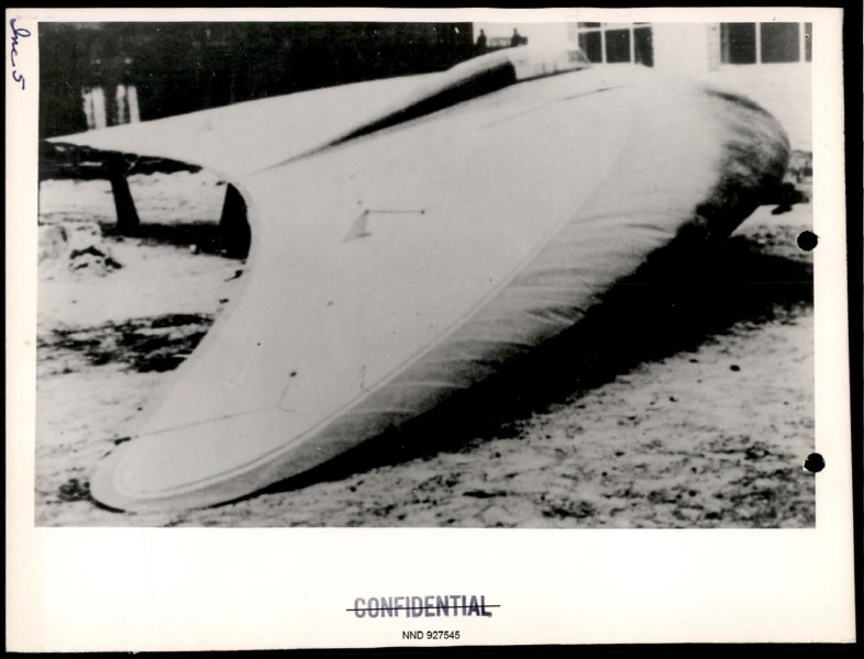 A black and white photograph of a large, delta-winged aircraft prototype resting on the ground, marked as confidential.