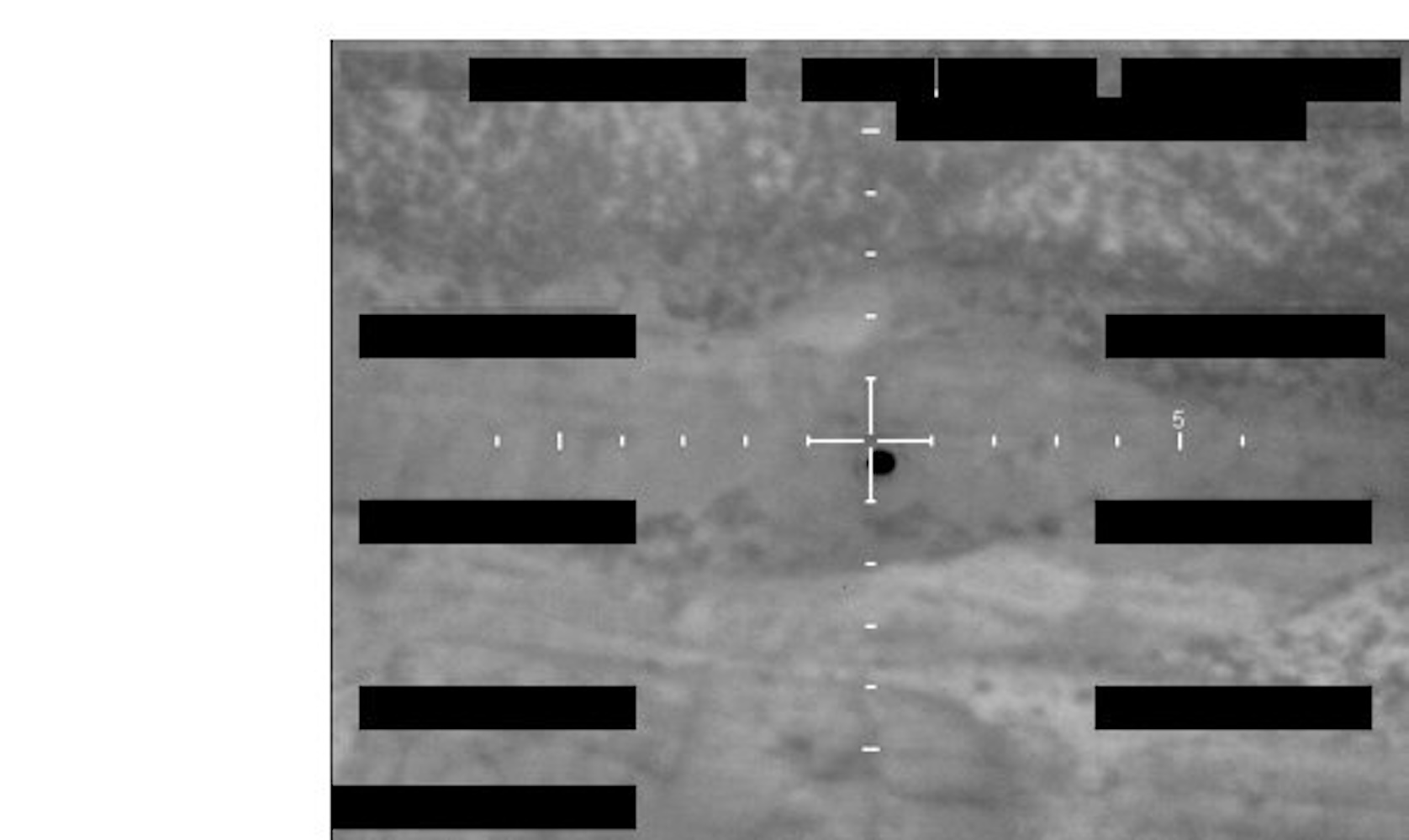 Redacted sensor image with a crosshair targeting an object.