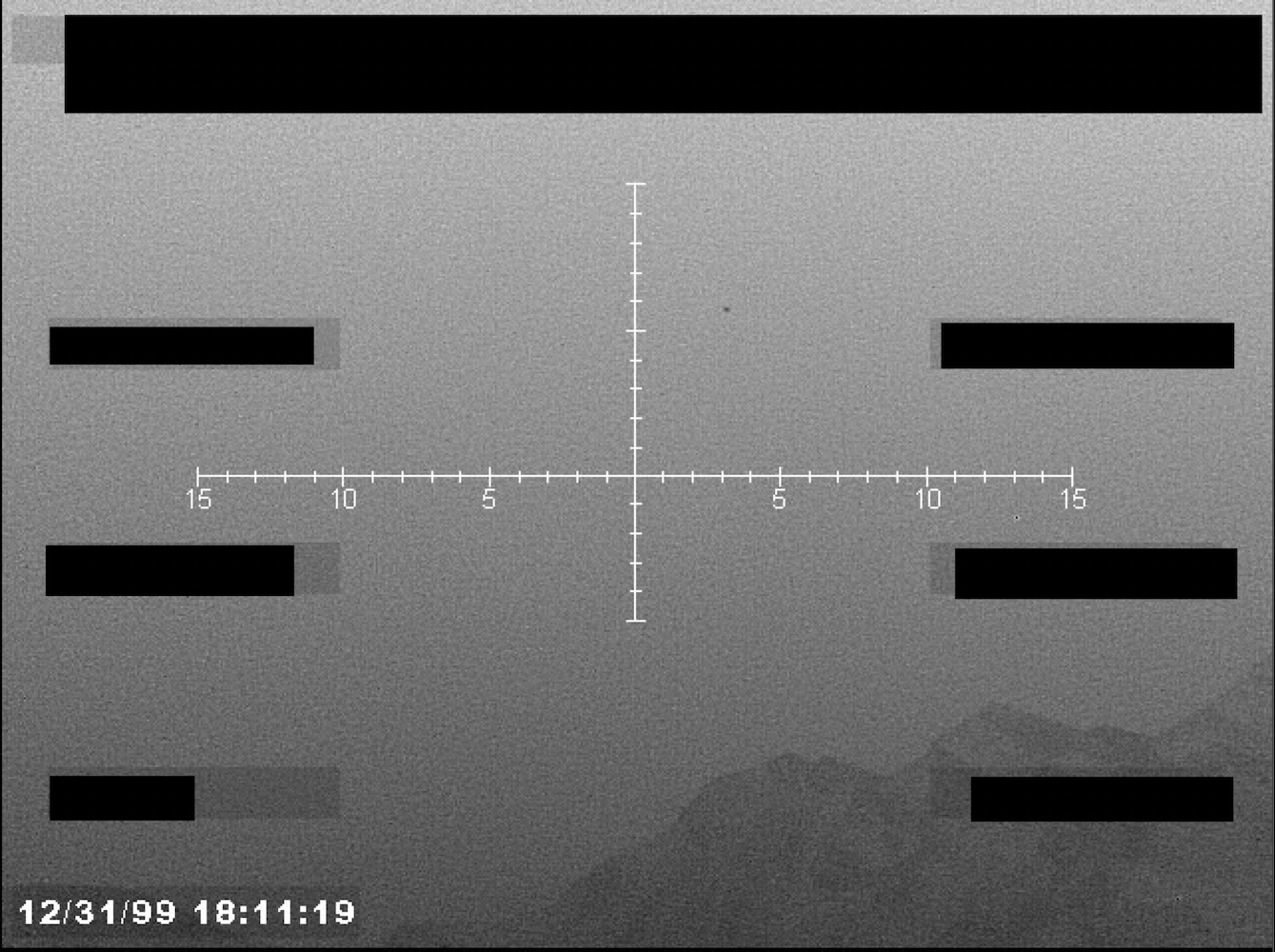 Redacted sensor image with a targeting reticle.