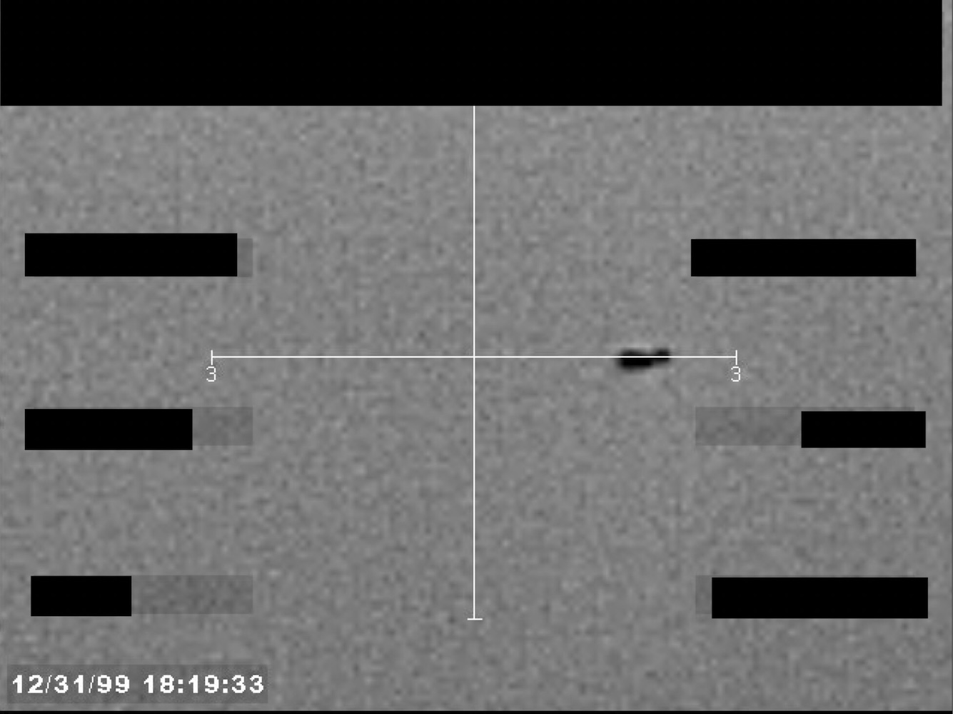 Redacted sensor image with a targeting reticle centered on an object.