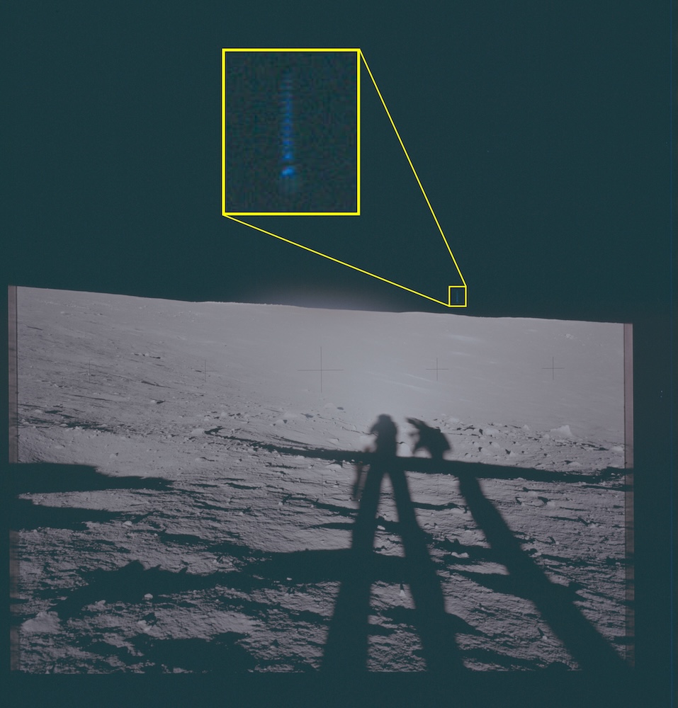 Photograph of the lunar surface showing astronaut shadows and a magnified callout of an object in the sky.