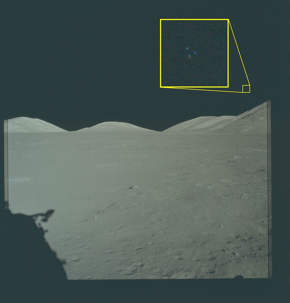 Photograph of the lunar surface showing astronaut shadows and a magnified callout of an object in the sky.